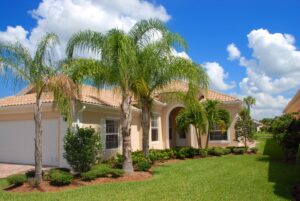 A Florida home with palm trees out front features stucco siding and a tile roof.