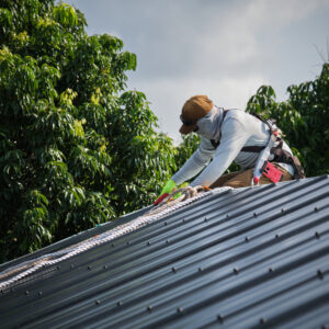 A worker works on a metal roof.