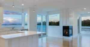 Vinyl windows in modern new home overlooking the water at sunset