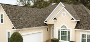 Brown asphalt shingles on a cream-colored home